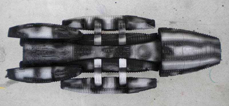 Maquette du vaisseau Battlestar Galactica vue de dessus, coque grise avec ombrages noirs au préombrage
