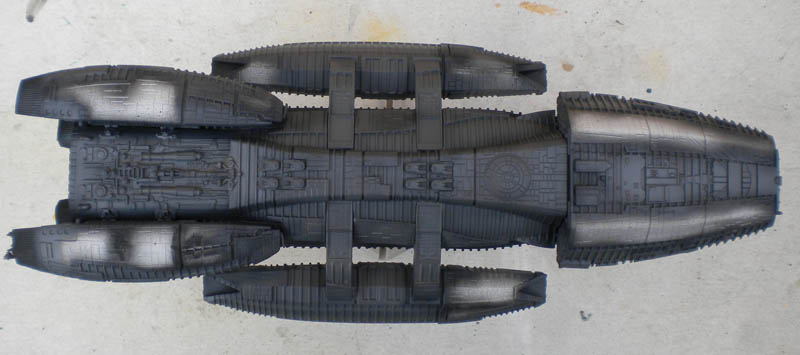 Maquette du vaisseau Battlestar Galactica vue de dessus avec apprêt gris en cours de montage