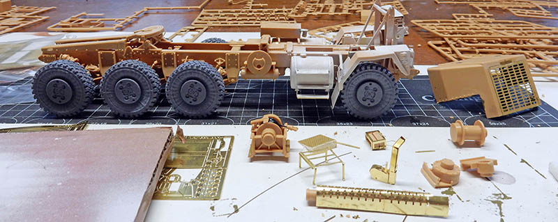 Châssis du HET 1070 Oshkosh en cours d'assemblage, entouré de pièces photodécoupées sur le tapis