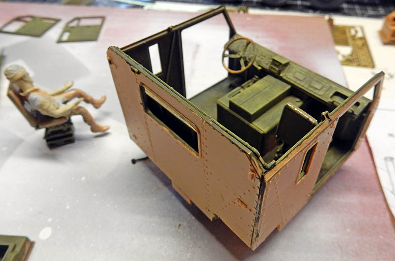 Cabine du HET 1070 Oshkosh en montage, intérieur détaillé, figurine du conducteur à côté