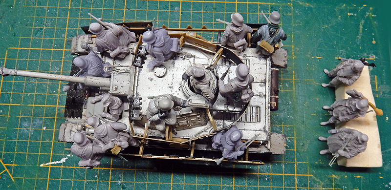 Maquette de char vue de dessus avec figurines de soldats en résine grise sur tapis de découpe