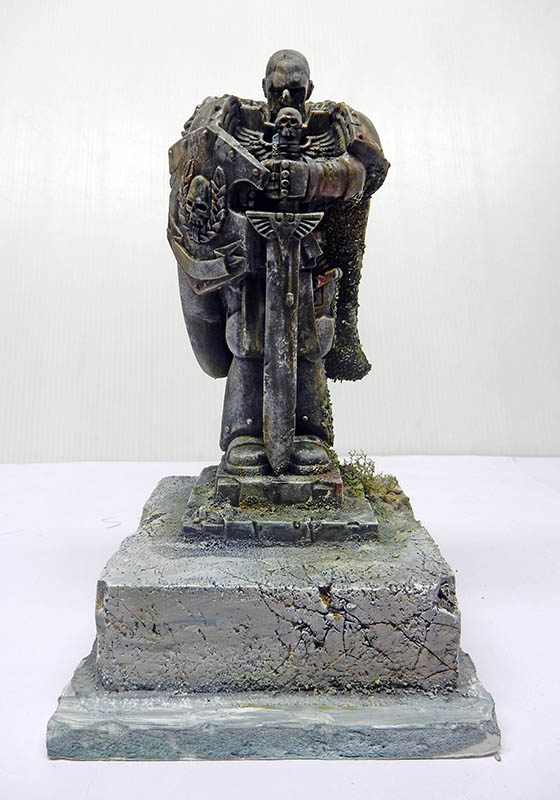 Statue de guerrier en armure, épée baissée, sur socle de pierre fissuré, patine mousse