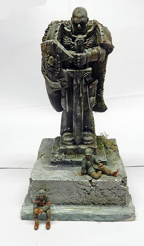 Diorama d'une statue monumentale patinée avec deux soldats blessés assis sur le socle