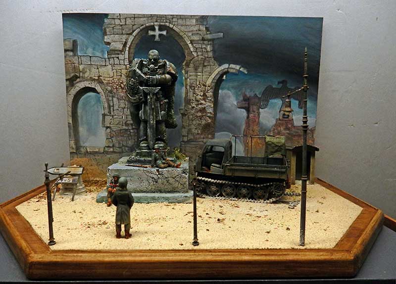 Diorama en cours de montage sur socle bois, statue, camion semi-chenillé et toile de fond peinte