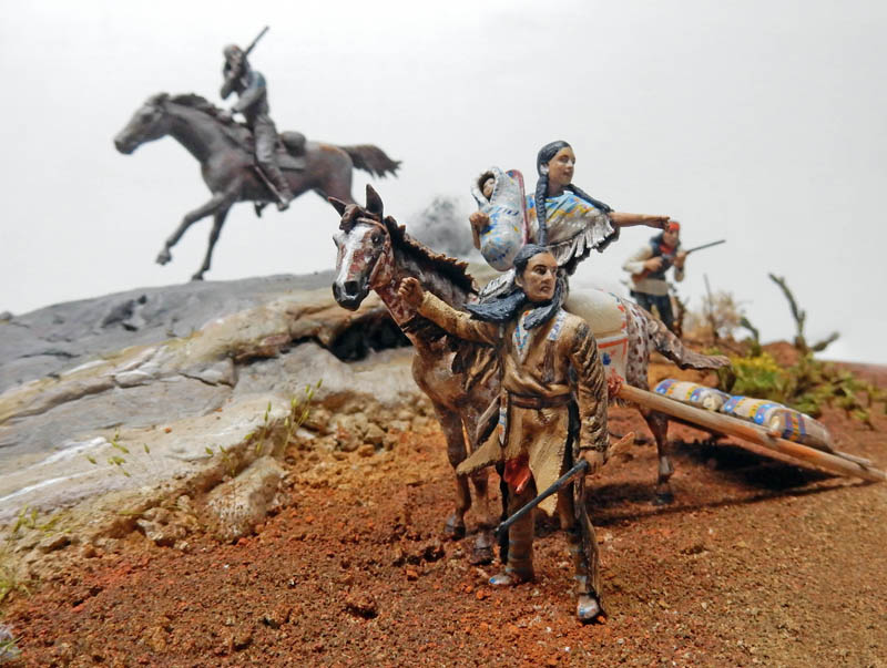 Diorama de figurines amérindiennes avec cheval tirant un travois, femme portant un enfant et cavalier au galop