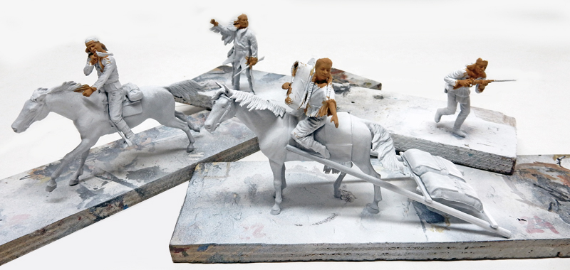 Figurines de maquettistes représentant des Indiens à cheval et à pied, apprêtées en gris avant peinture