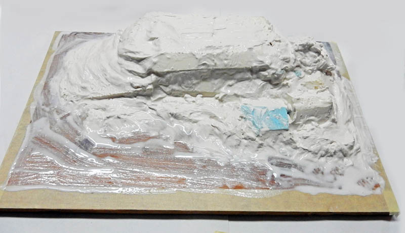 Maquette de diorama en cours, relief rocheux modelé au plâtre blanc sur socle en bois