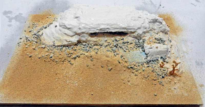 Maquette de diorama en construction avec relief en plâtre, sable et gravats sur socle