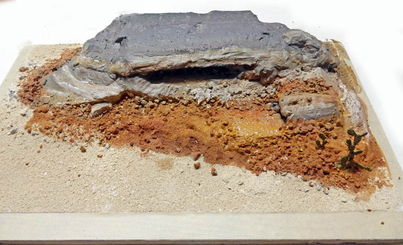 Diorama de maquette représentant un terrain désertique rocheux avec sable, cailloux et cactus