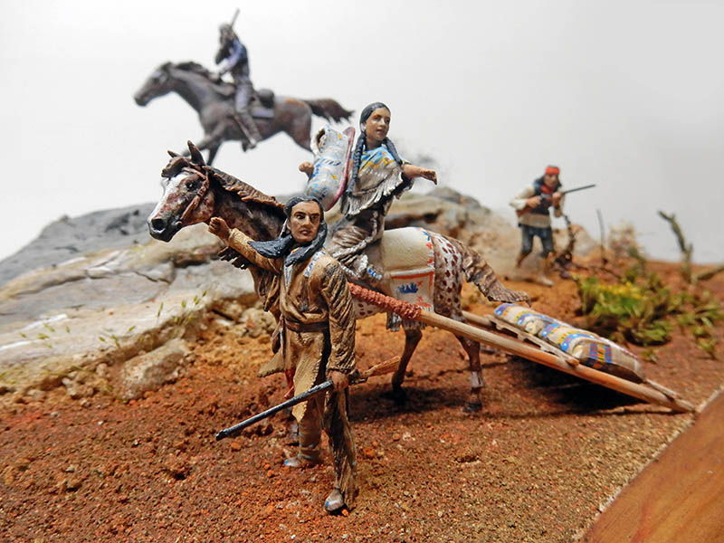 Diorama de figurines d'Indiens avec cheval tirant un travois, guerriers et femme à cheval
