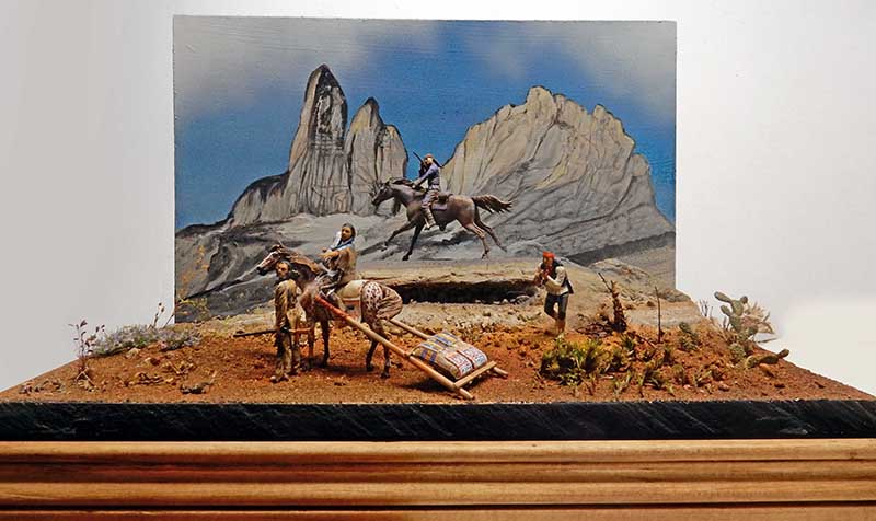 Diorama de figurines indiens à cheval dans un paysage désertique avec montagnes rocheuses en arrière-plan