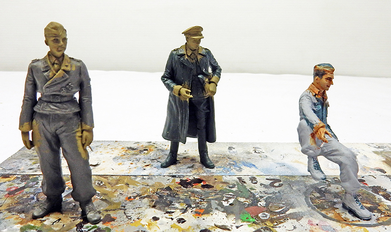 Trois figurines peintes de soldats allemands de l'équipage du Jagdpanther sur palette de peinture