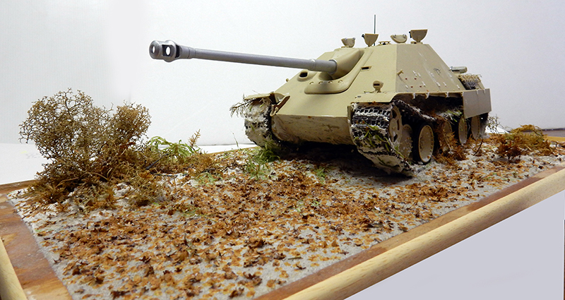 Maquette de Jagdpanther beige sur diorama avec buisson sec et sol couvert de feuilles