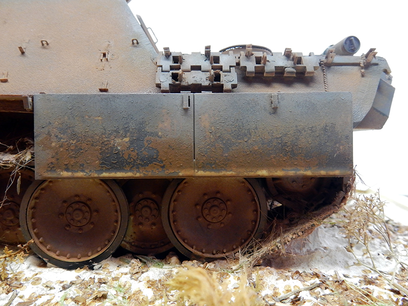 Vue latérale de la maquette Jagdpanther montrant le blindage patiné et les roues vieillies sur diorama