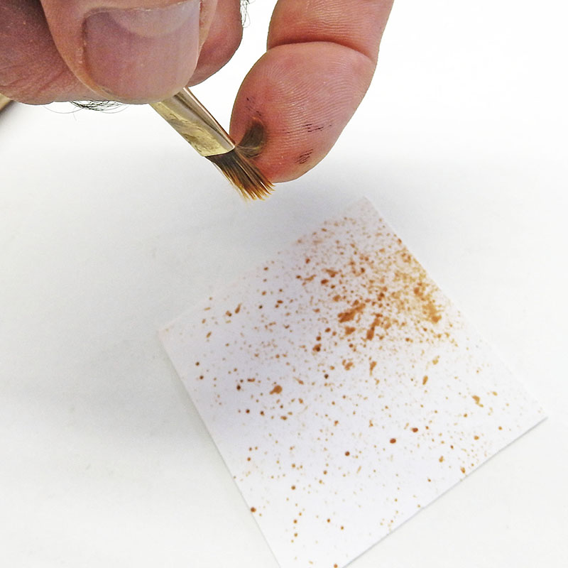 Technique de projection de peinture marron au pinceau pour créer des éclaboussures sur papier