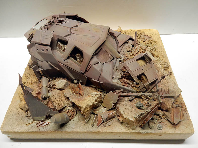 Maquette de véhicule blindé écrasé sur un diorama de débris et décombres sablonneux