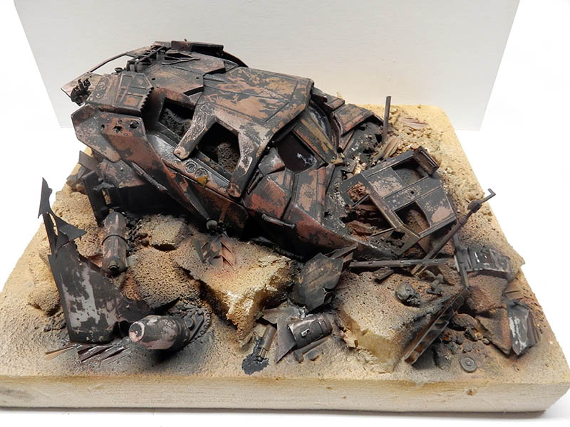 Maquette de cyborg blindé rouillé en ruine sur un diorama de sable et débris