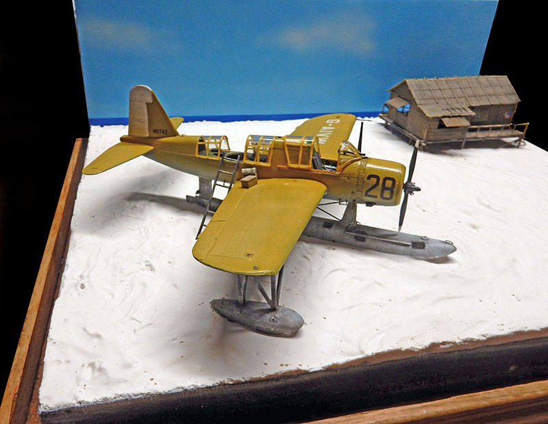 Maquette de Vought OS2U Kingfisher jaune sur flotteurs, diorama de plage avec cabane sur pilotis