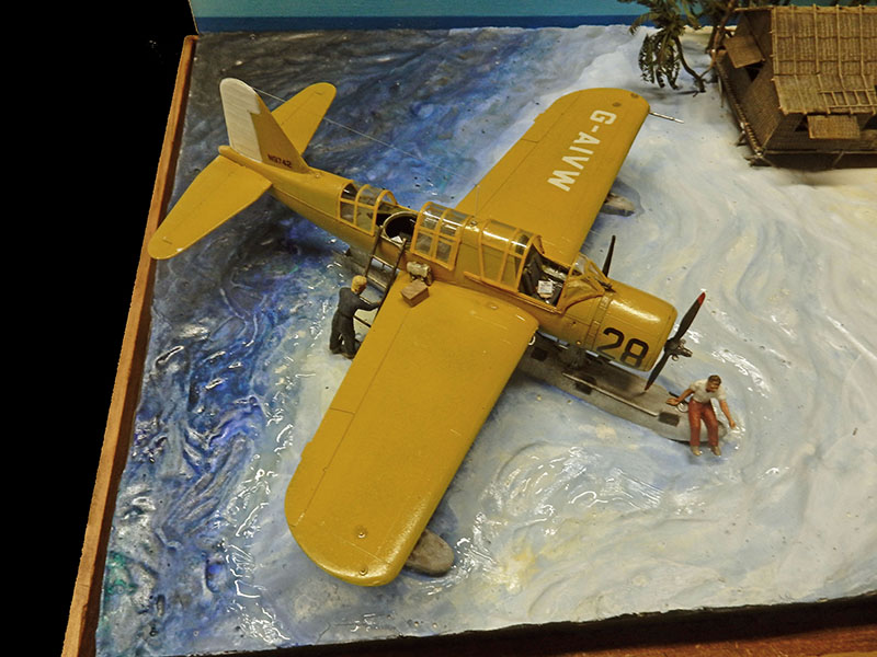Maquette d'hydravion Vought OS2U Kingfisher jaune sur diorama d'eau avec figurines