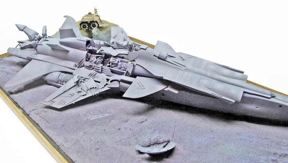 Maquette kitbash d'épave d'avion de chasse écrasé sur diorama de sol gris