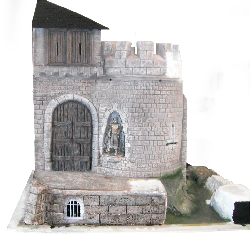 Maquette de donjon médiéval en pierre avec porte en bois et statue de chevalier