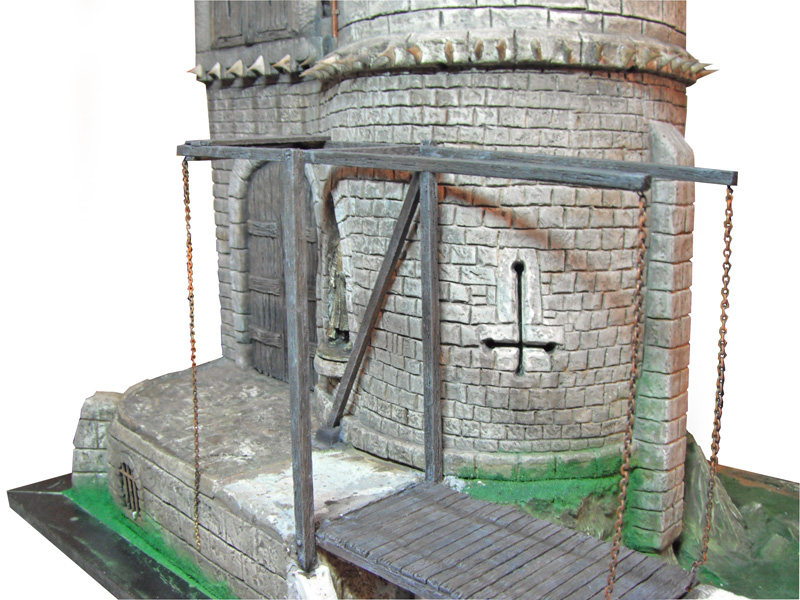Maquette de donjon médiéval en pierre avec pont-levis en bois et chaînes rouillées