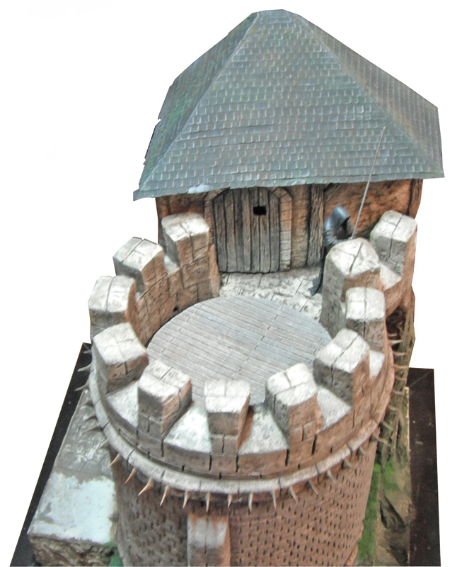 Maquette du sommet d'un donjon médiéval avec créneaux, toit en tuiles et garde armé