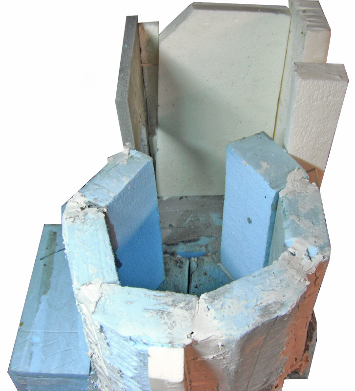 Maquette de donjon en construction avec blocs de polystyrène bleu et enduit gris