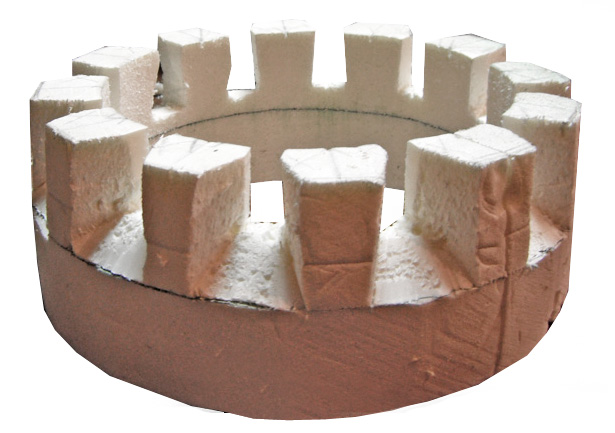 Maquette de donjon circulaire en carton et plâtre avec créneaux blancs sur muraille ronde