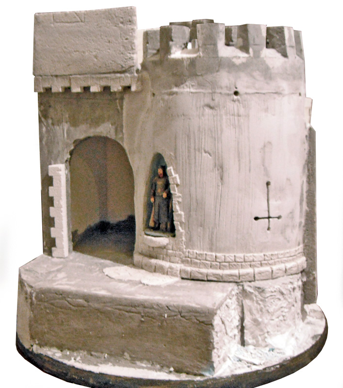 Maquette de donjon médiéval crénelé avec figurine et porte voûtée sur socle