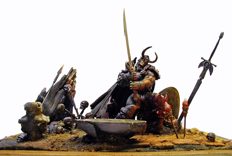 Diorama de figurine guerrier cornu brandissant une épée parmi crânes et lances sur socle sablonneux