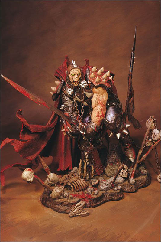 Figurine de guerrier monstrueux en armure à pointes brandissant une épée sanglante parmi des ossements