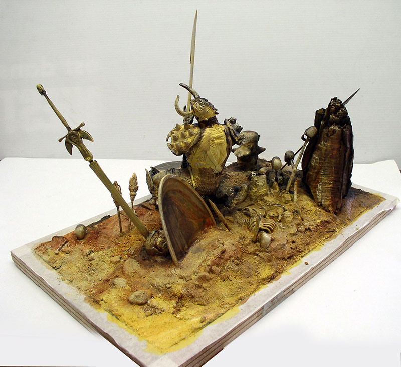 Diorama de maquette représentant un guerrier cornu armé d'un bouclier sur un sol désertique parsemé d'ossements