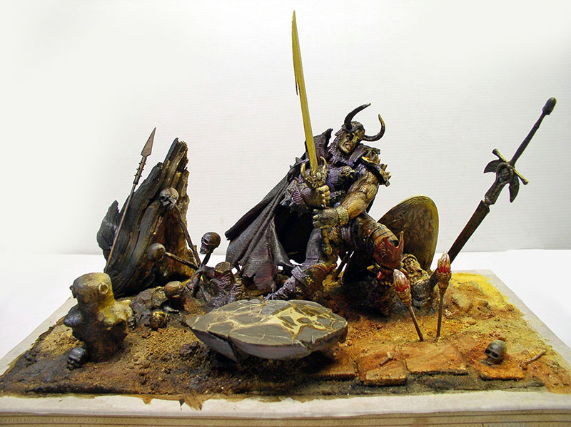 Diorama figurine guerrier cornu brandissant une épée parmi crânes et lances sur socle sablonneux