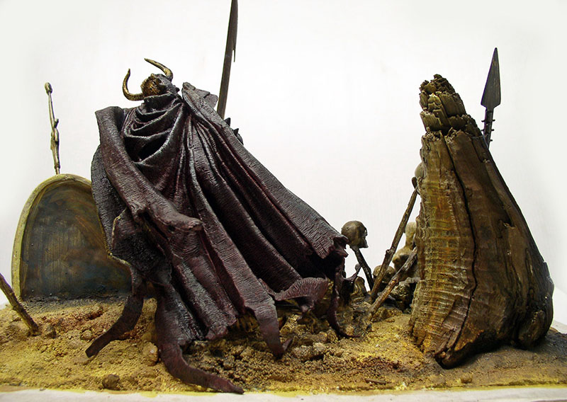Diorama de figurine encapuchonnée à cornes près d'une souche, lances et squelette sur sol sablonneux