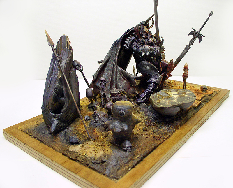 Diorama du Libérateur, guerrier sombre armé entouré de crânes, lances et rochers sur socle bois
