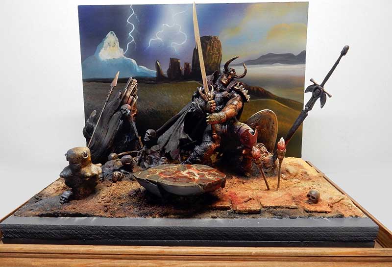 Diorama du Libérateur, guerrier cornu à l'épée parmi crânes et armes, décor désertique peint