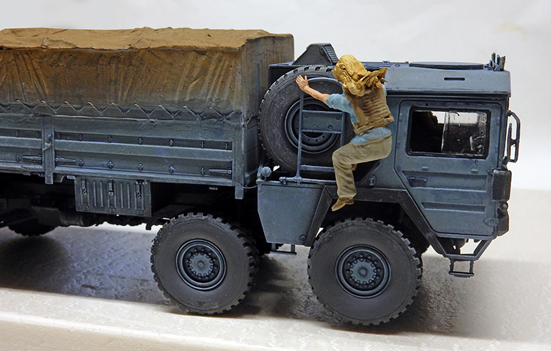 Maquette de camion militaire bâché gris avec figurine grimpant le long de la cabine