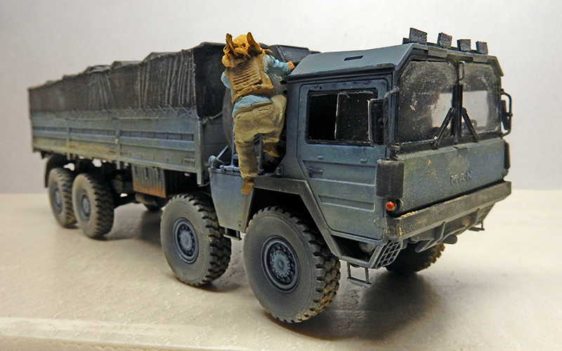 Maquette de camion militaire MAN gris avec figurine de soldat montant dans la cabine