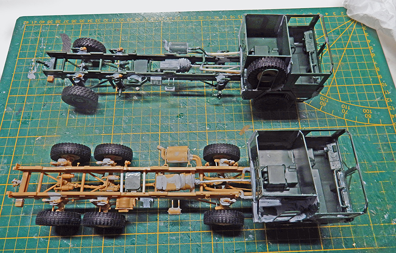 Deux châssis de camions miniatures en cours de montage sur tapis de découpe vert