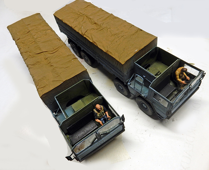 Deux maquettes de camions bâchés avec figurines de conducteurs dans les cabines ouvertes