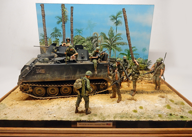 Char M113 A1 ACAV peint en vert olive avec tourelle de mitrailleuse et boucliers blindés latéraux