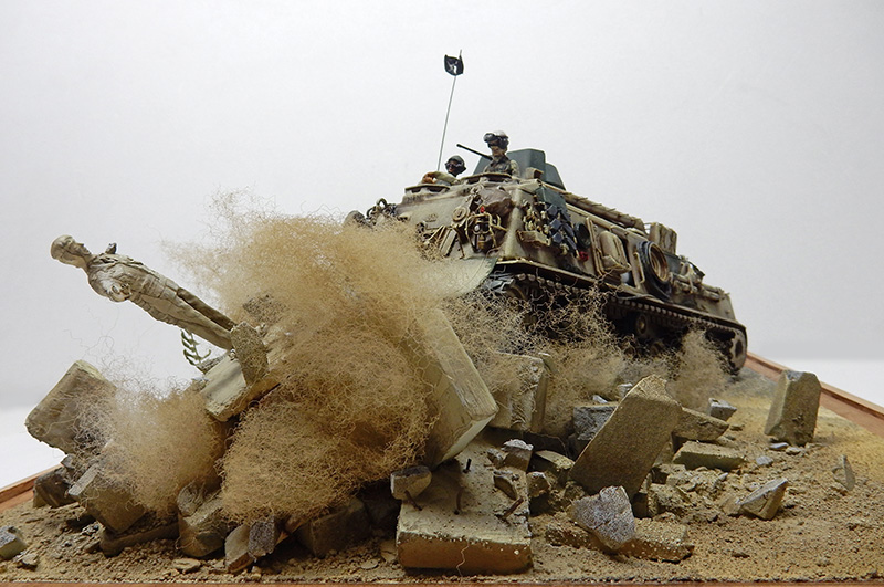 Diorama du M88A1 renversant une statue dans un décor désertique de gravats
