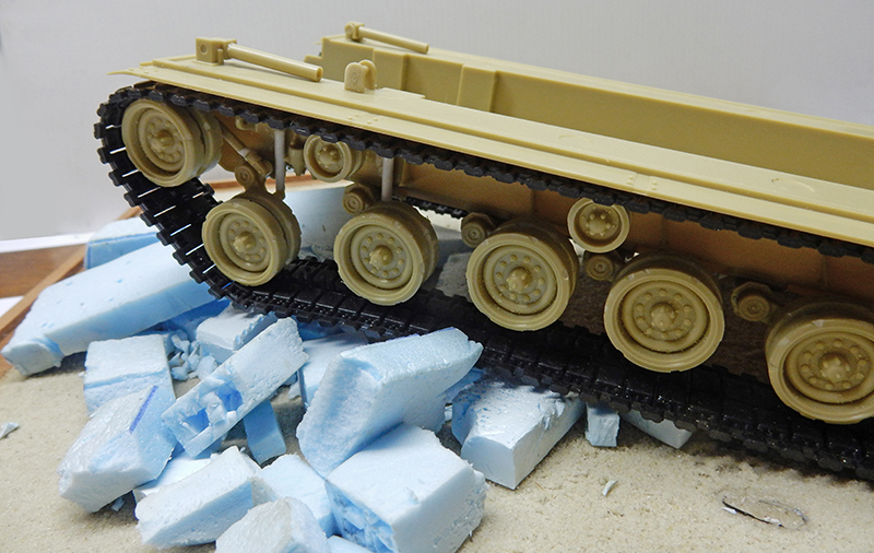 Train de roulement du M88A1 en cours d'assemblage, chenilles posées, débris de mousse bleue