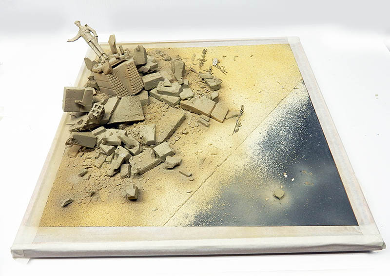 Socle de décor en cours de construction, ruines et gravats sur sable, avant peinture