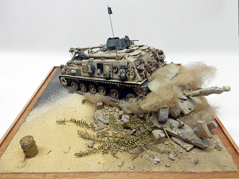 Diorama du M88A1 sable soulevant la poussière parmi gravats, végétation sèche et bidon