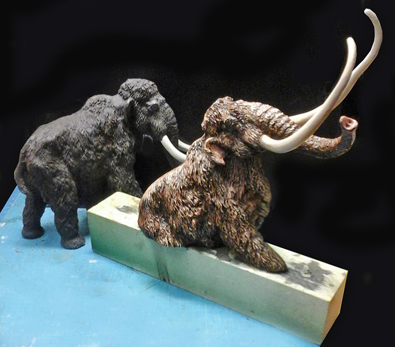 Deux maquettes de mammouths laineux à l'échelle 1/32, l'une peinte en brun, l'autre en gris
