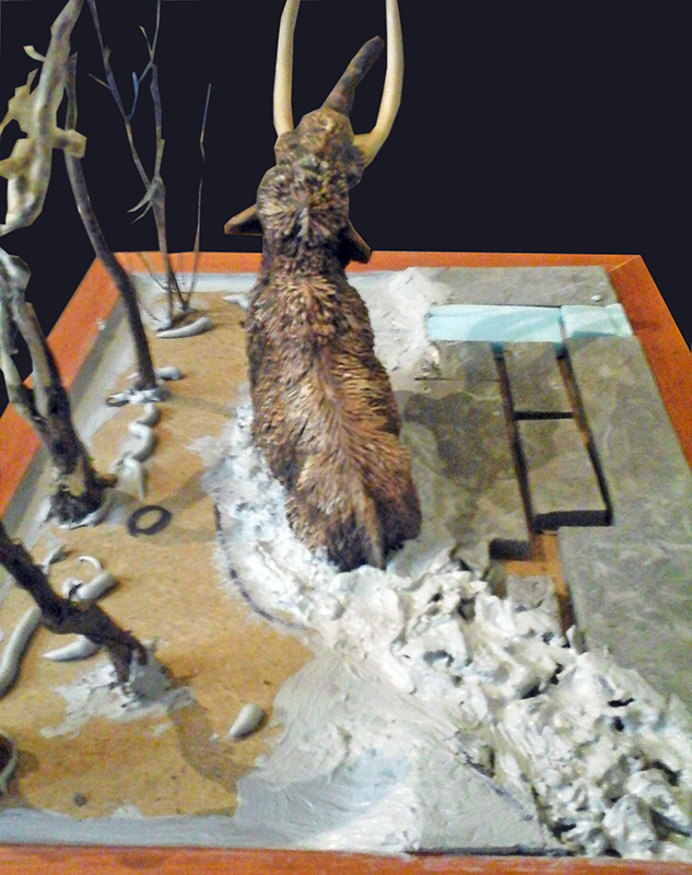Maquette de mammouth laineux vu de dos sur diorama enneigé avec arbres morts