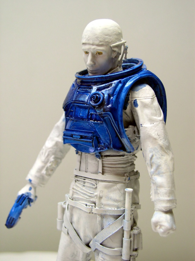 Figurine de personnage en cours de peinture avec armure bleue brillante et combinaison blanche