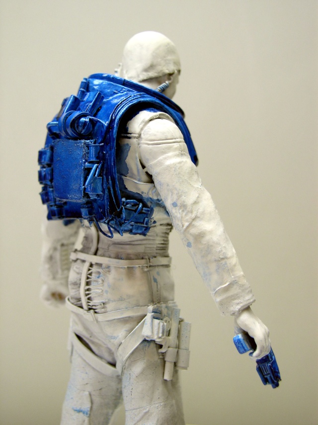 Figurine de soldat de dos avec sac à dos bleu en cours de peinture